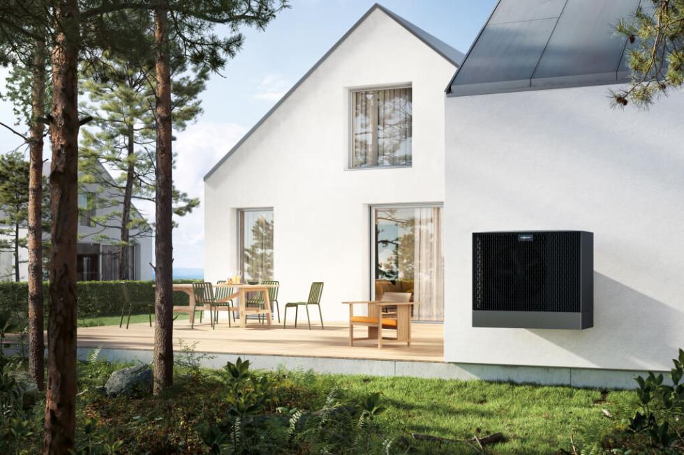 Ein modernes weißes Haus am Waldrand heizt und kühlt mit einer Wärmepumpe